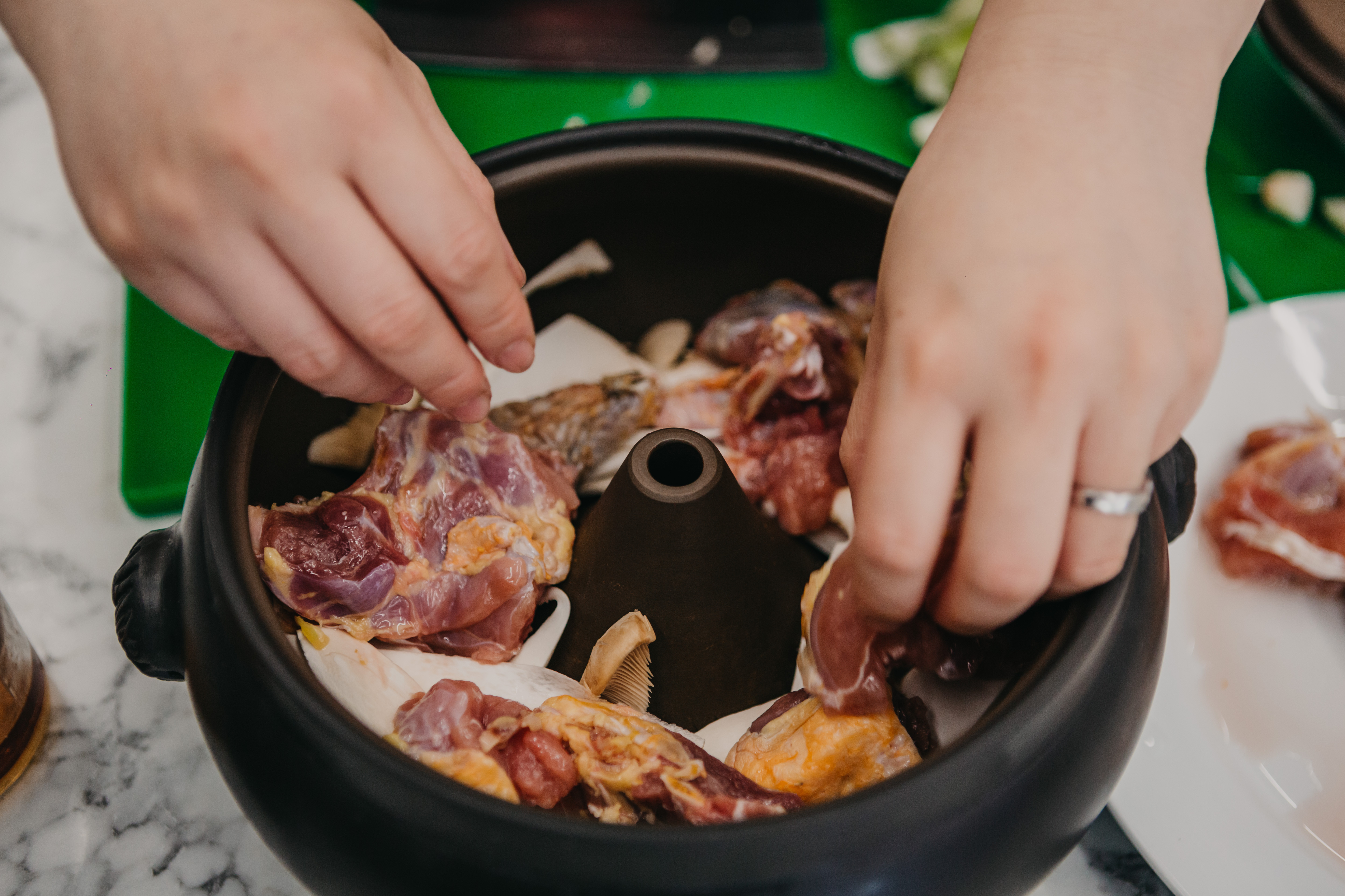 Person arranging ingredients in a Chinese hot pot